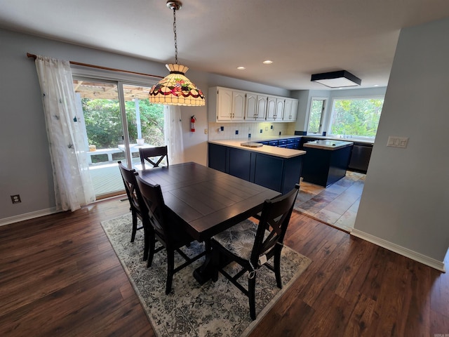 dining room with dark wood-type flooring, recessed lighting, and baseboards