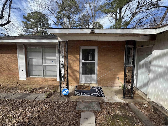 entrance to property featuring brick siding