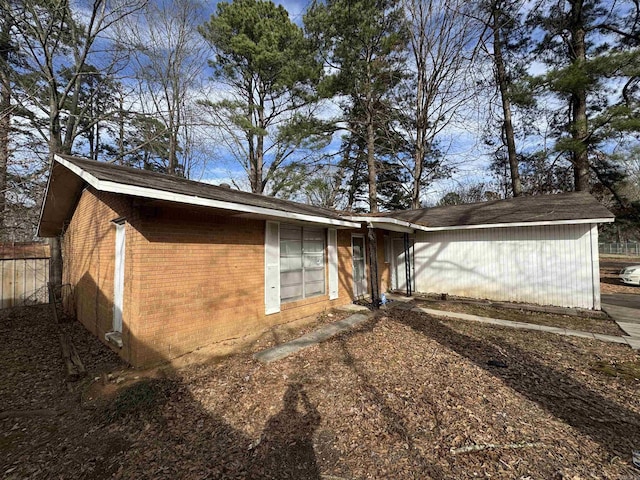 rear view of property with fence and brick siding