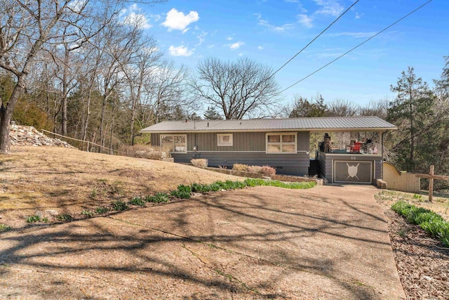 view of front facade with crawl space, concrete driveway, a garage, and metal roof