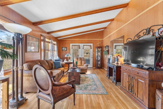 living area featuring lofted ceiling with beams, light wood-style floors, and wooden walls