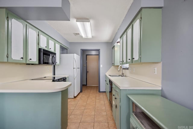 kitchen featuring a sink, light tile patterned flooring, green cabinets, and black microwave