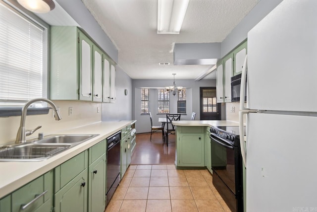 kitchen with green cabinets, light countertops, light tile patterned floors, black appliances, and a sink