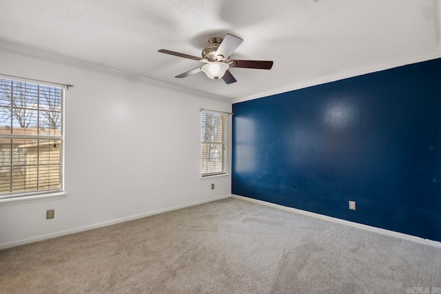 unfurnished room with plenty of natural light, carpet flooring, baseboards, and ornamental molding