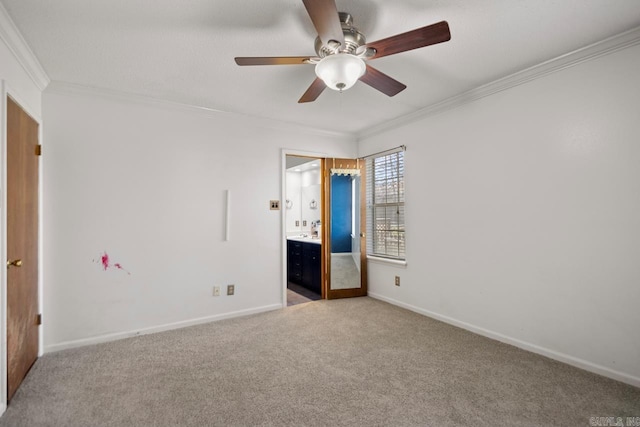 unfurnished bedroom with ensuite bath, crown molding, baseboards, light colored carpet, and ceiling fan