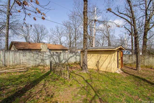 view of yard with an outbuilding, a shed, and a fenced backyard