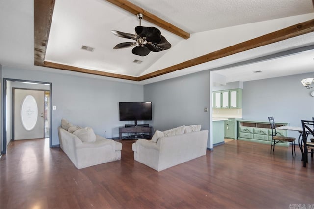 living area featuring dark wood-type flooring, lofted ceiling with beams, ceiling fan with notable chandelier, and visible vents