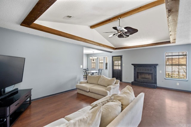 living area with visible vents, vaulted ceiling with beams, ceiling fan with notable chandelier, a fireplace, and a textured ceiling