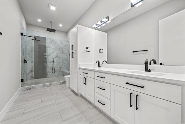 full bathroom featuring double vanity, a stall shower, toilet, and a sink