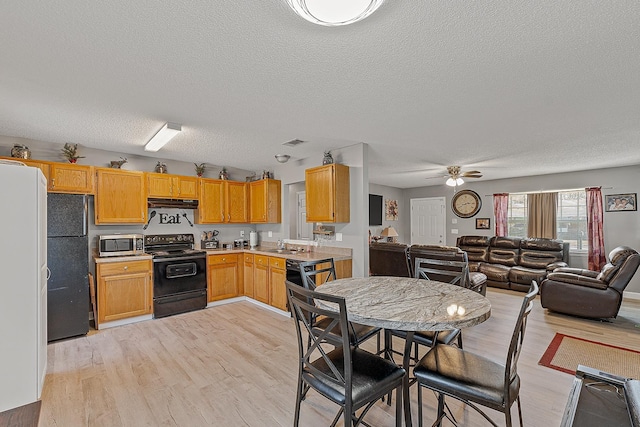 kitchen featuring visible vents, black appliances, light countertops, and light wood-type flooring