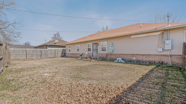 rear view of house with a fenced backyard and brick siding