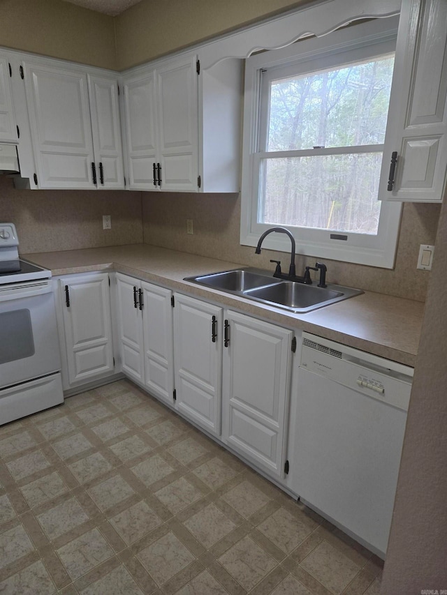 kitchen with white cabinetry, white appliances, light floors, and a sink