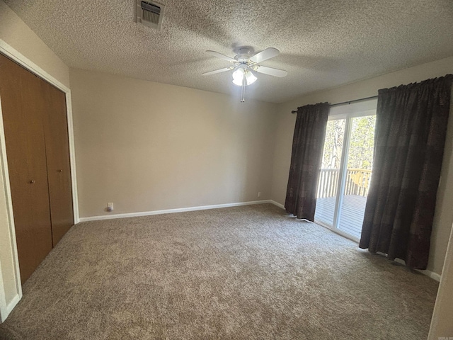 carpeted spare room with visible vents, a textured ceiling, baseboards, and ceiling fan