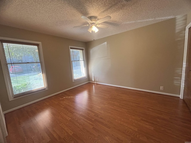 empty room featuring a ceiling fan, wood finished floors, baseboards, and a textured ceiling