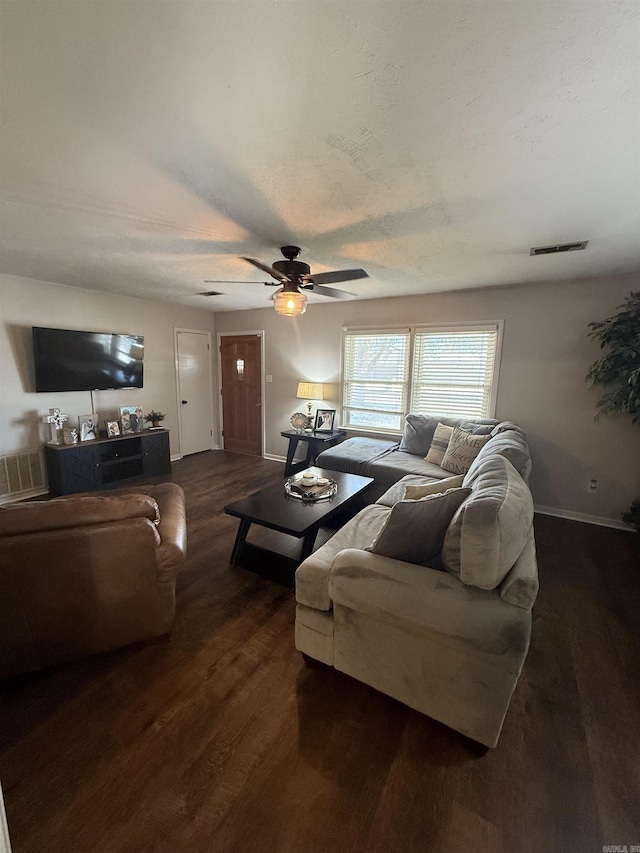 living room with visible vents, dark wood-type flooring, a textured ceiling, baseboards, and ceiling fan