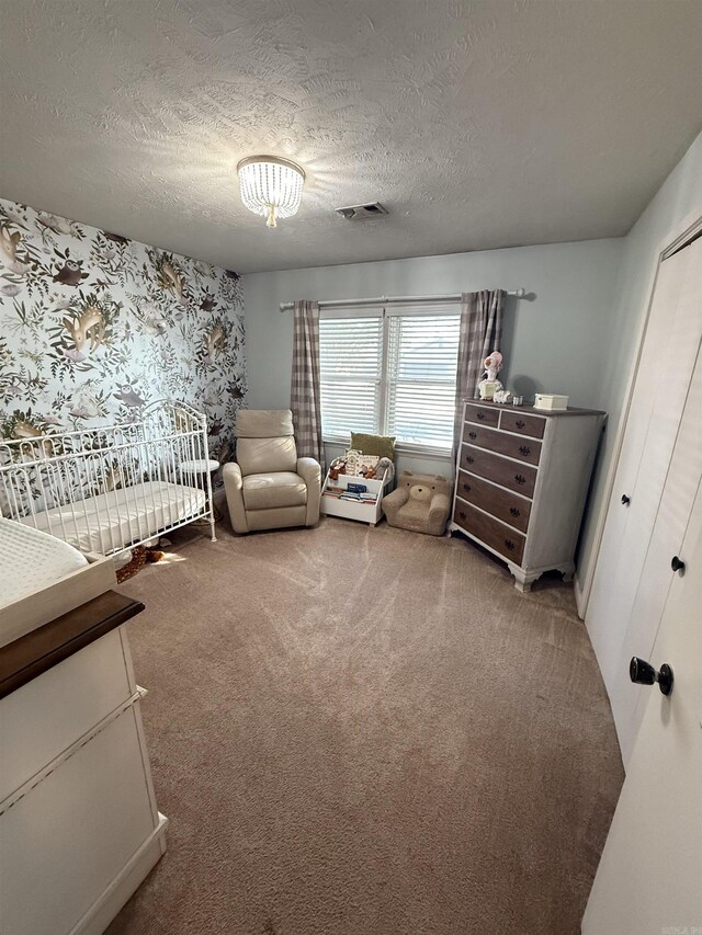 bedroom featuring visible vents, carpet floors, and a textured ceiling