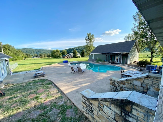 outdoor pool with an outdoor structure, a yard, a patio area, and an exterior structure