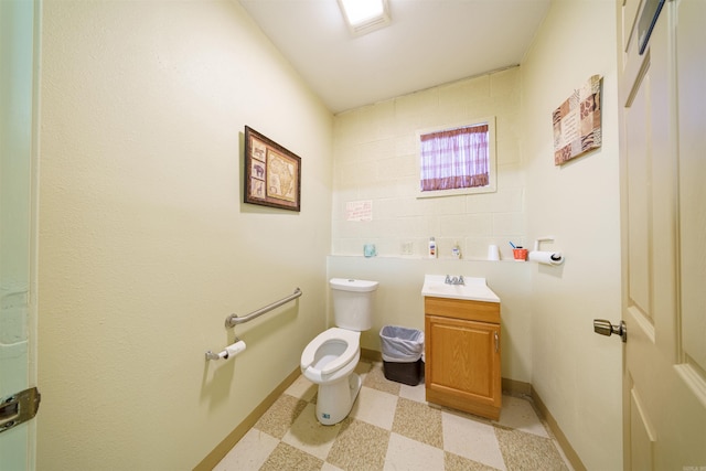 bathroom with vanity, tile patterned floors, toilet, and baseboards