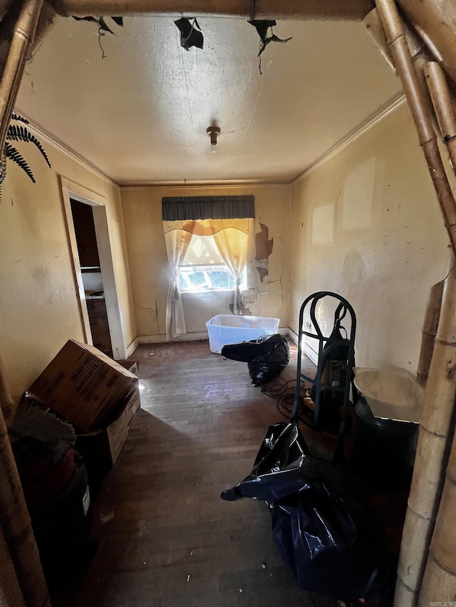 interior space with baseboards, wood finished floors, and crown molding