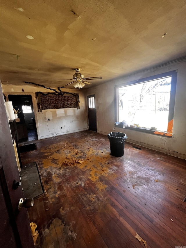 unfurnished living room with visible vents, wood-type flooring, and a ceiling fan