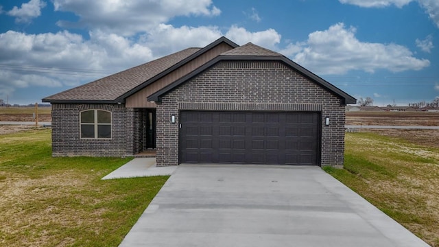 view of front facade with a front lawn, an attached garage, brick siding, and concrete driveway