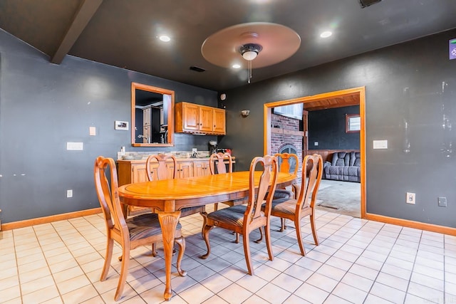 dining space featuring beam ceiling, light tile patterned floors, visible vents, and baseboards