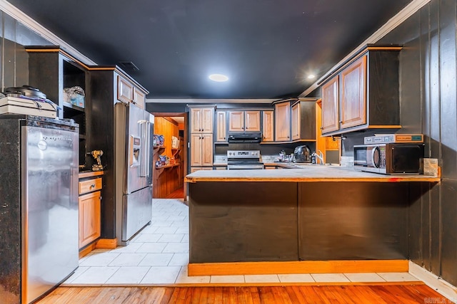 kitchen featuring ventilation hood, a peninsula, a sink, light countertops, and appliances with stainless steel finishes