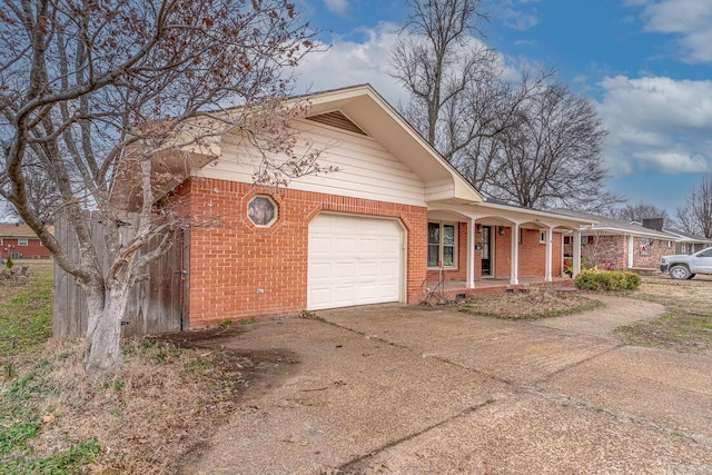 view of front of house featuring a porch, brick siding, a garage, and driveway