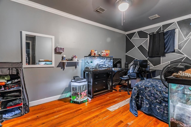 bedroom with visible vents, wood finished floors, baseboards, and ornamental molding