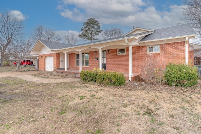 ranch-style home with a garage, brick siding, a porch, and driveway