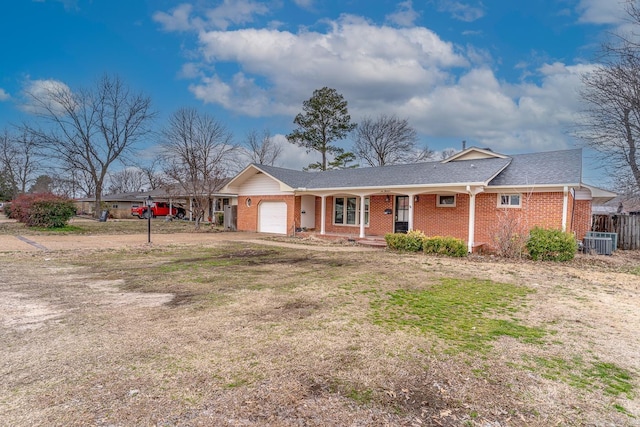 ranch-style house with brick siding, dirt driveway, a porch, central AC, and an attached garage