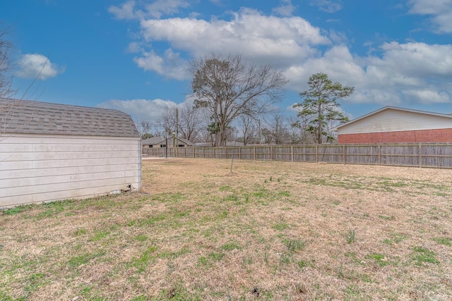 view of yard featuring a storage shed, an outdoor structure, and fence