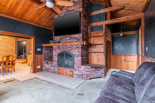 living room with lofted ceiling, an outdoor brick fireplace, wood walls, wainscoting, and wooden ceiling