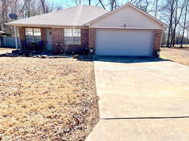 single story home with an attached garage, brick siding, driveway, and roof with shingles