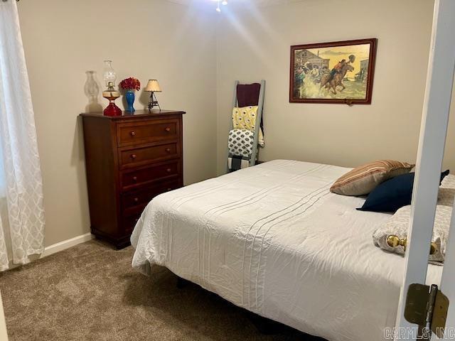 bedroom featuring baseboards and carpet