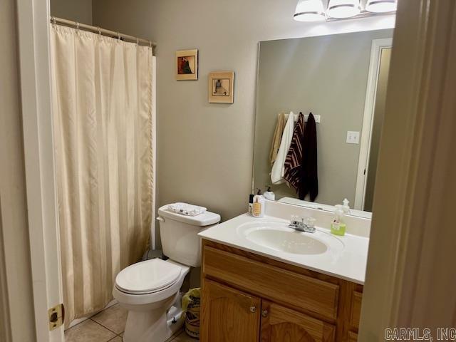 bathroom featuring toilet, vanity, and tile patterned flooring