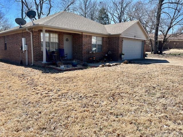 ranch-style home with driveway, a garage, brick siding, and roof with shingles