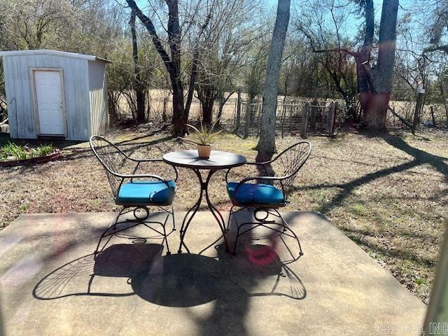 view of patio with an outbuilding and a storage unit