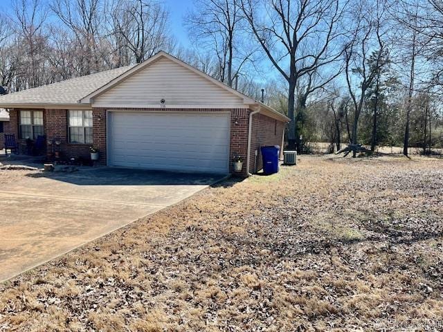 view of home's exterior with brick siding, driveway, and an attached garage