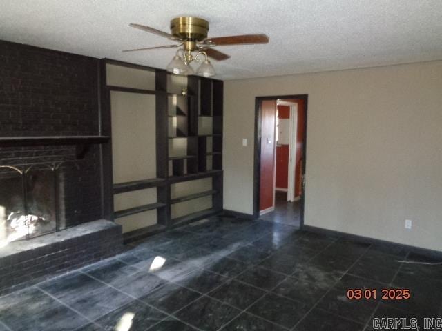 unfurnished living room featuring baseboards, a textured ceiling, a brick fireplace, and ceiling fan