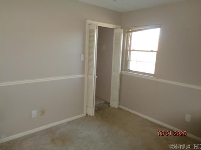 unfurnished bedroom featuring carpet, baseboards, and a closet