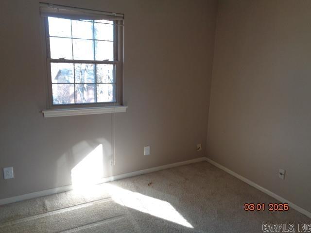 carpeted spare room featuring baseboards