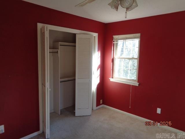 unfurnished bedroom featuring carpet flooring, baseboards, and a closet