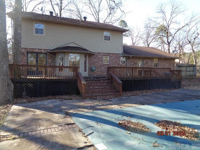 back of property featuring a patio, fence, brick siding, and a wooden deck