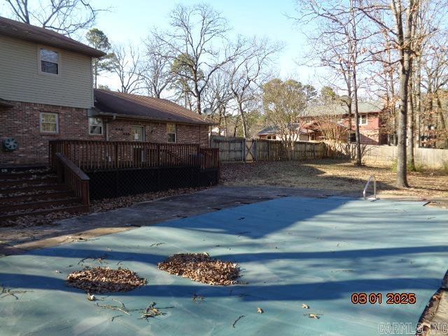 view of pool with a wooden deck and a fenced backyard