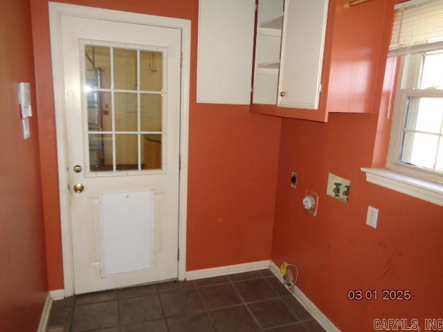 clothes washing area with baseboards, hookup for an electric dryer, washer hookup, and dark tile patterned floors