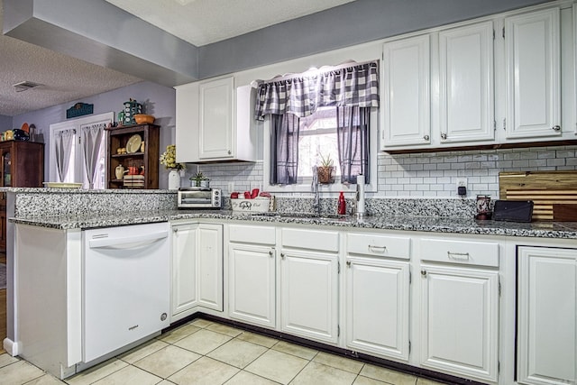 kitchen featuring visible vents, a peninsula, white cabinetry, and white dishwasher