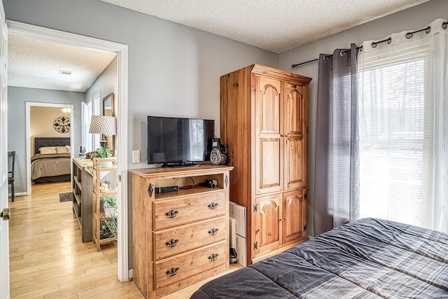 bedroom with light wood-style flooring and a textured ceiling