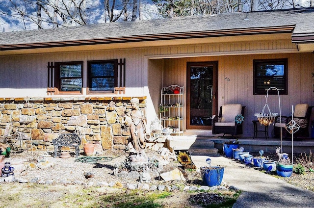 entrance to property featuring roof with shingles