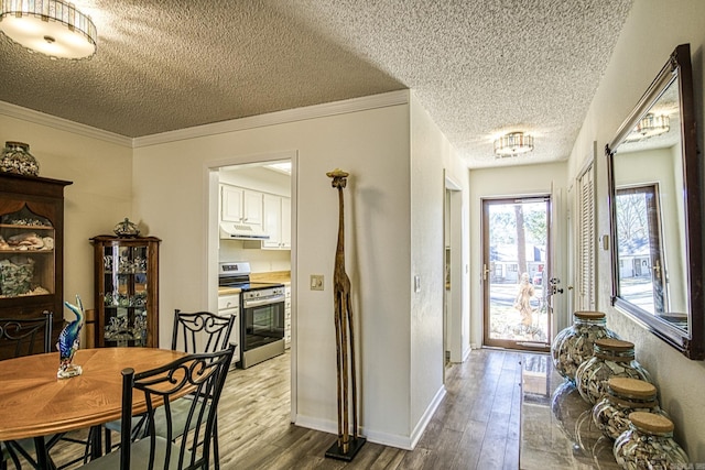 interior space featuring baseboards, wood finished floors, and ornamental molding